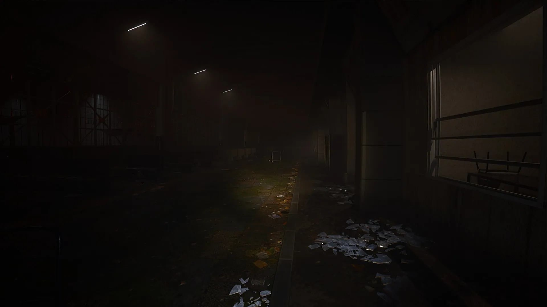 Dark hall with tall windows and debris on the floor
