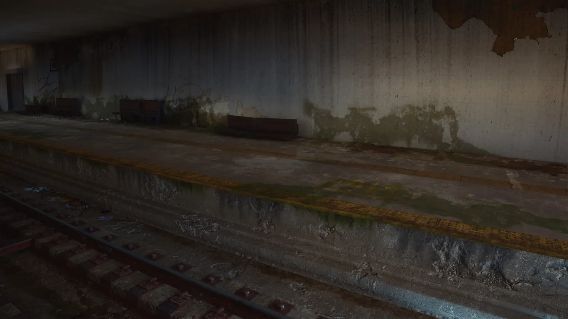 Abandoned subway platform with mossy walls beside the tracks